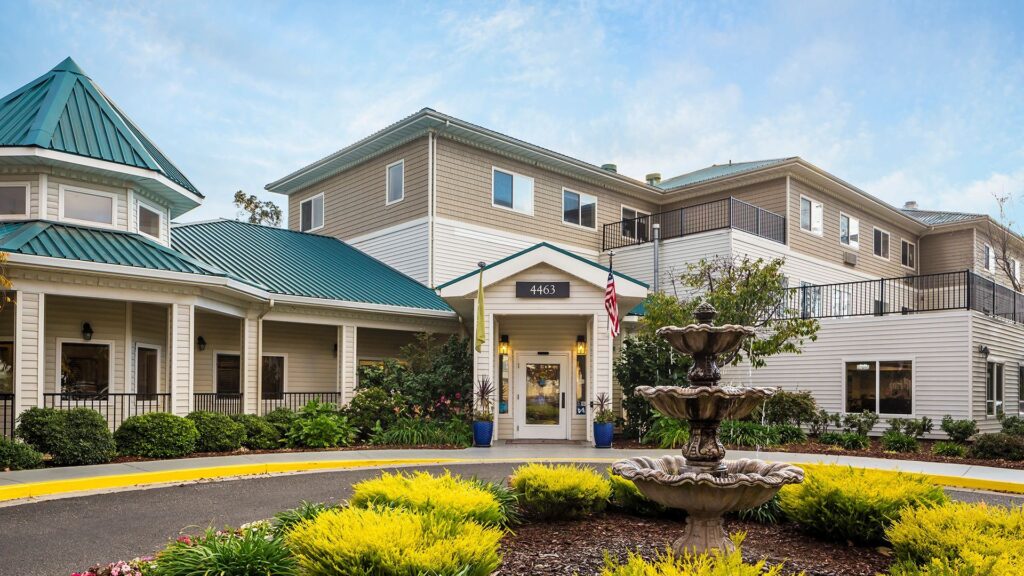 Entrance of Evergreen senior living facility with landscaped gardens and an American flag