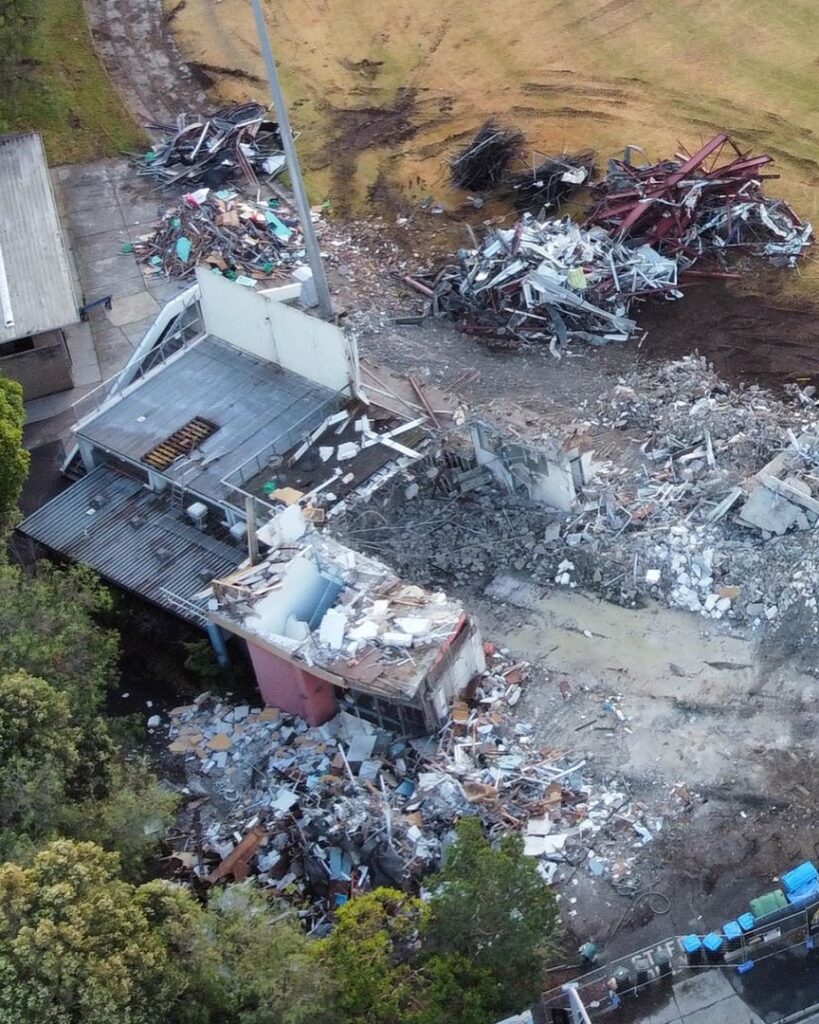 Aerial view of a demolition site with piles of debris and remnants of demolished structures.