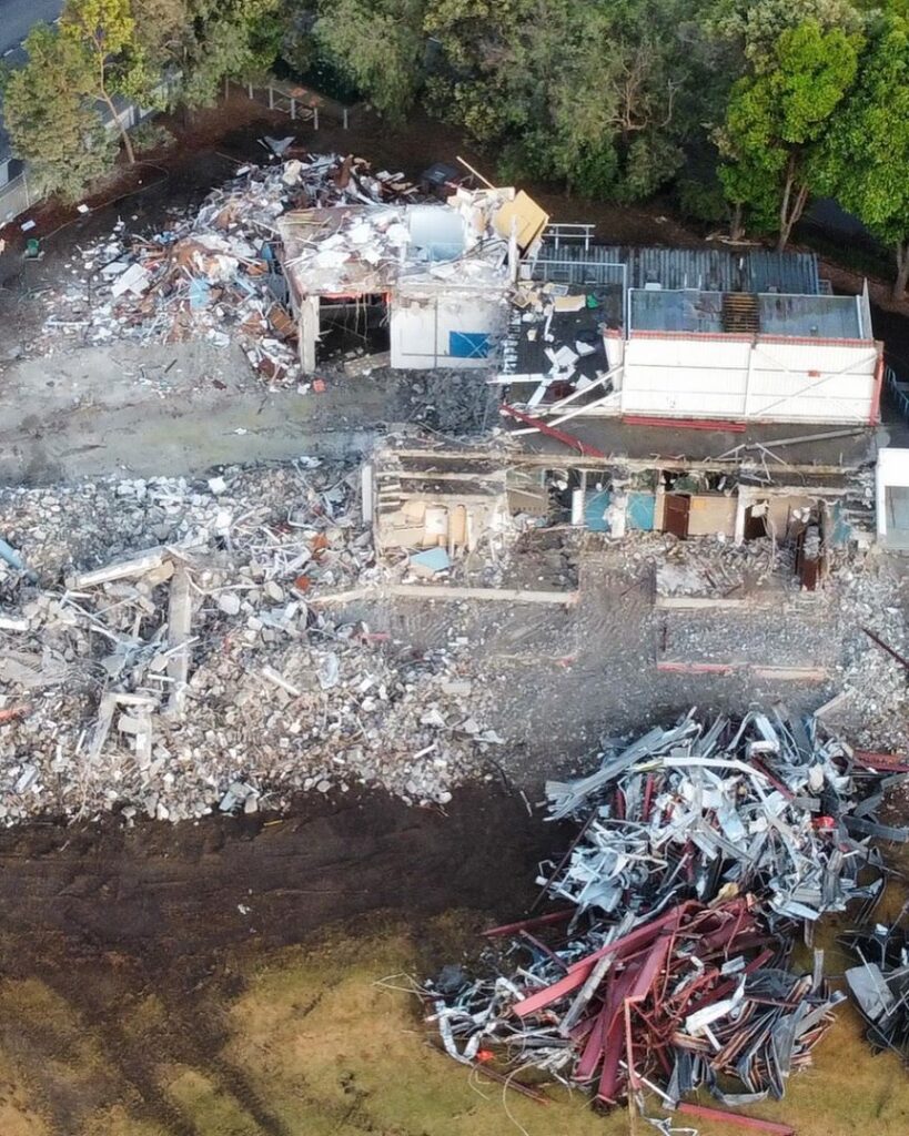 Aerial view of a demolition site with debris and partially collapsed structures.