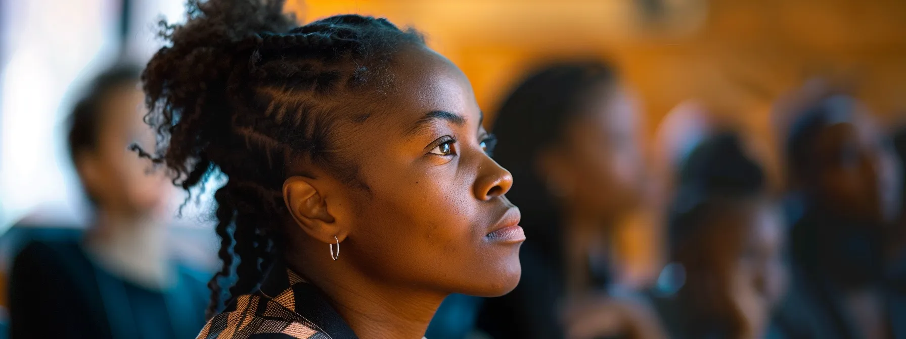 a person participating in a workshop, deep in thought, with a look of contemplation and empowerment on their face.