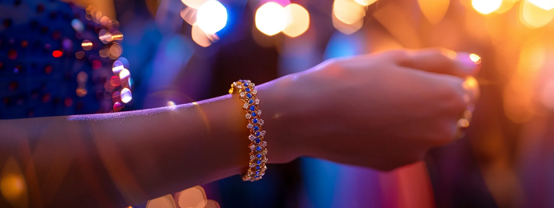 a woman's wrist adorned with a shimmering sapphire and gold gemstone bracelet, catching the light beautifully at a formal event.