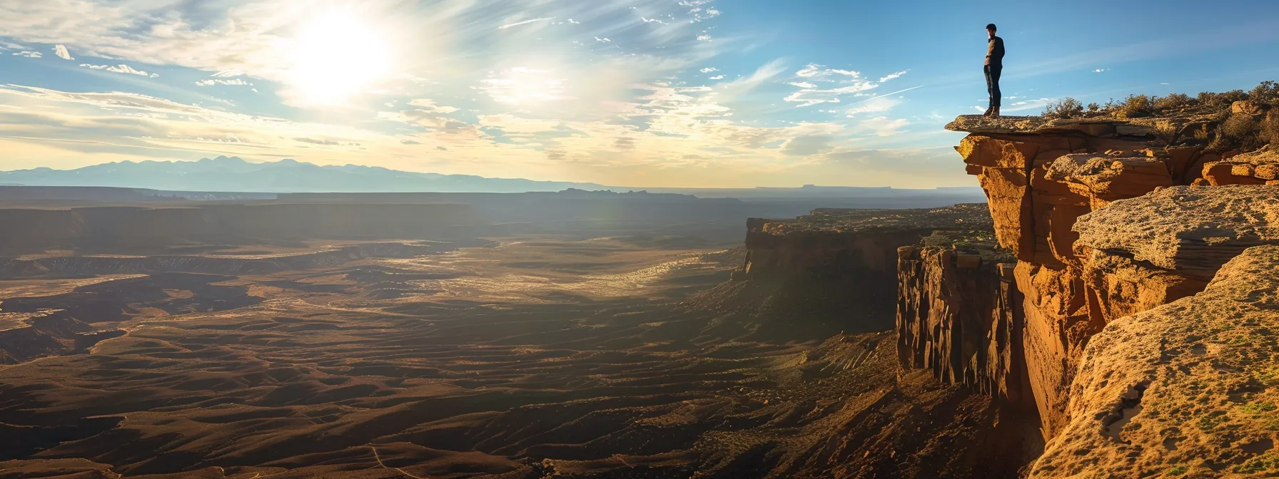 a person standing at the edge of a cliff, overlooking a vast landscape with open skies and endless possibilities.