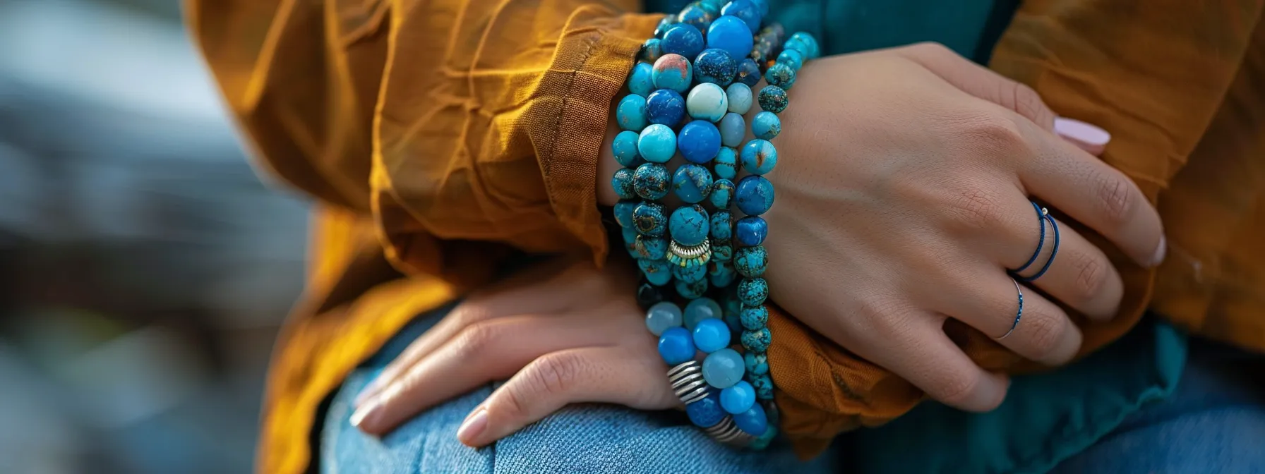 a person wearing turquoise, chalcedony, and lapis lazuli gemstone bracelets, radiating a sense of emotional balance and harmony.