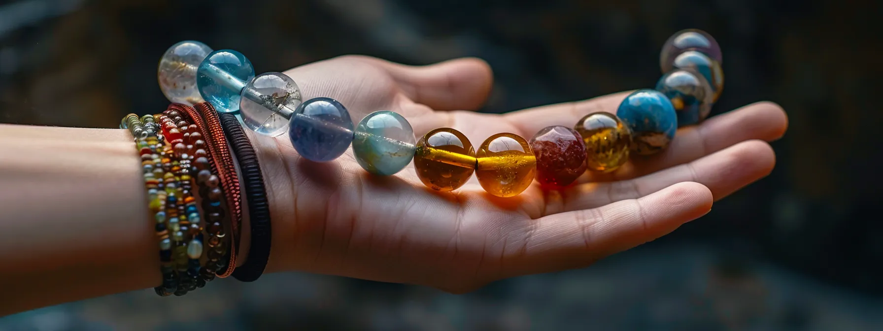 a hand holding different sizes of gemstone beads for a bracelet.