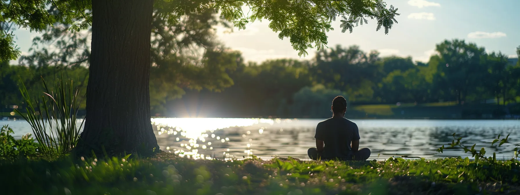 a person deep in thought, contemplating their mindset and growth on a peaceful lakeside.