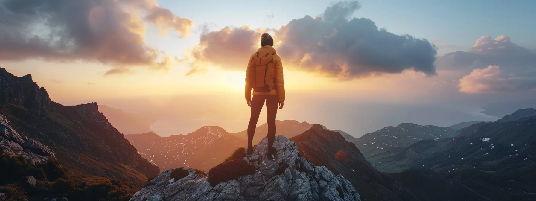 a person standing confidently at the top of a mountain, gazing out at a beautiful landscape.