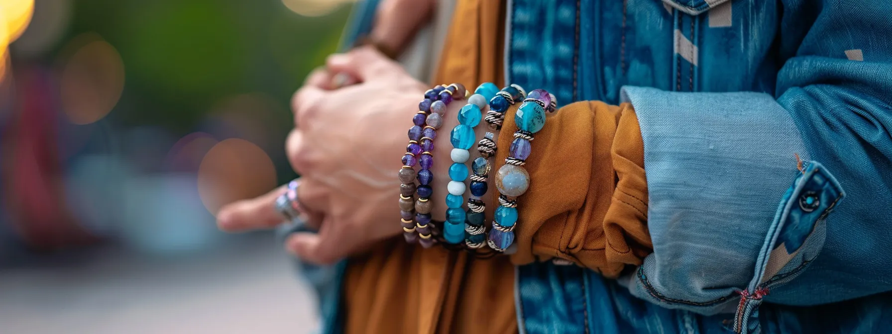 a person wearing a stack of gemstone bracelets with a casual outfit, adding a touch of elegance to their look.