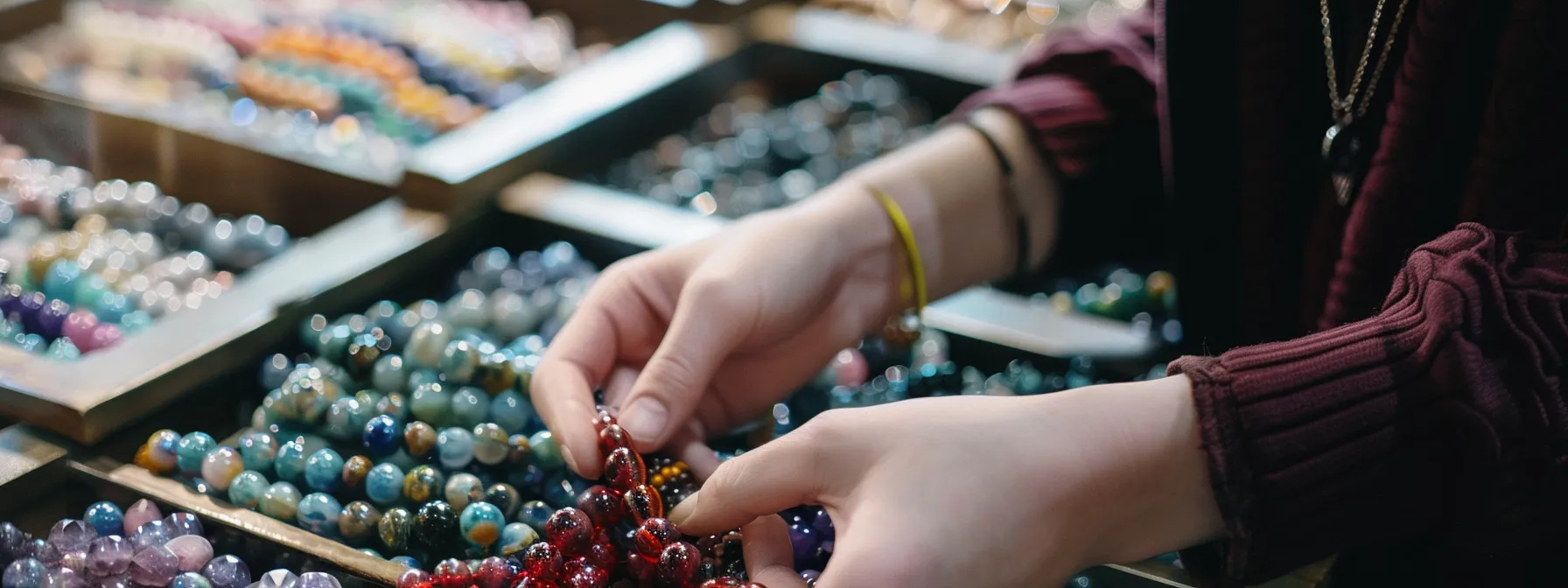 a person carefully selecting and rotating natural gemstone bracelets to maintain their longevity.