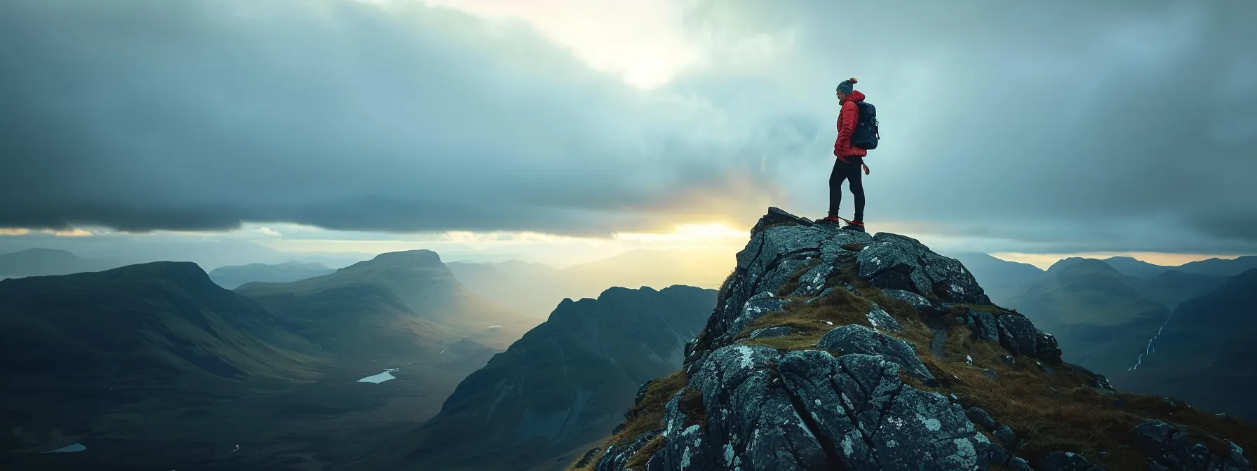 a person standing on top of a mountain, looking towards the horizon with a determined expression on their face.