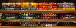 a collection of colorful gemstone bracelets arranged on a wooden display stand.