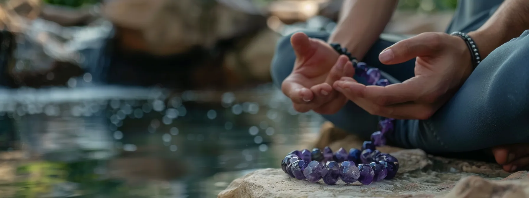 a person wearing an amethyst gemstone bracelet while practicing deep breathing exercises in a peaceful setting.