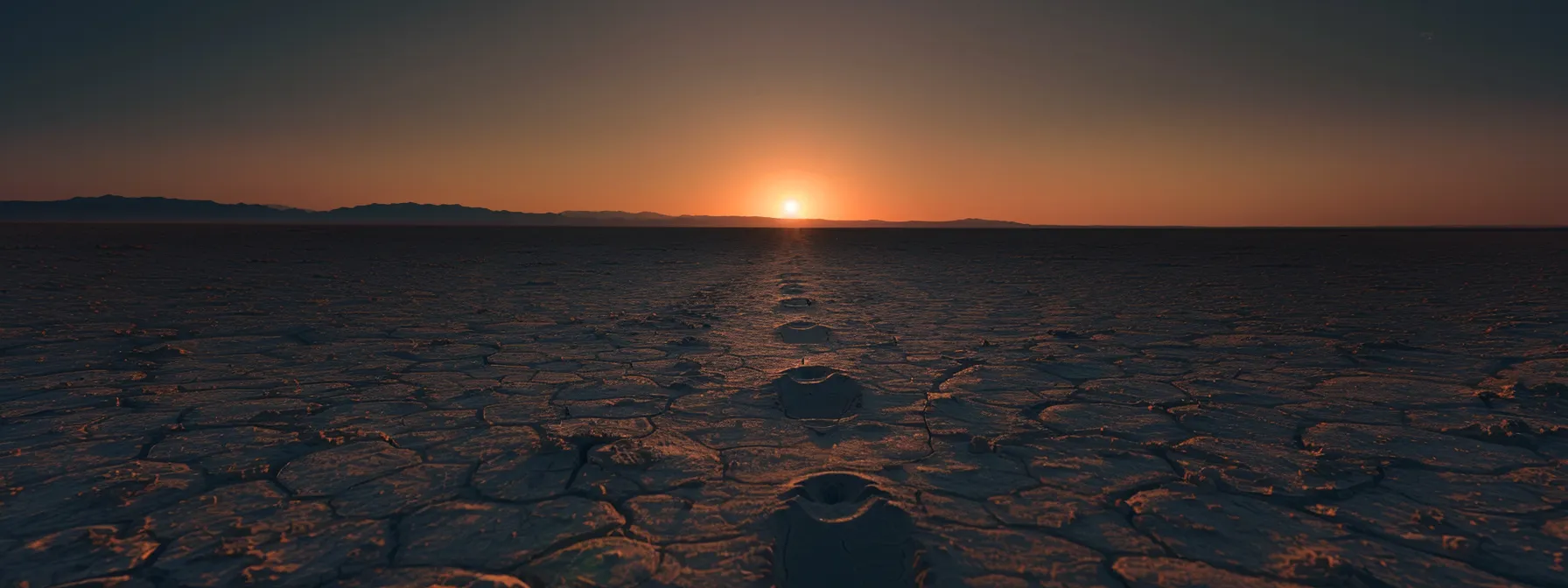 a trail of footprints leading towards a glowing horizon, symbolizing gradual progress and consistency in building lasting habits.