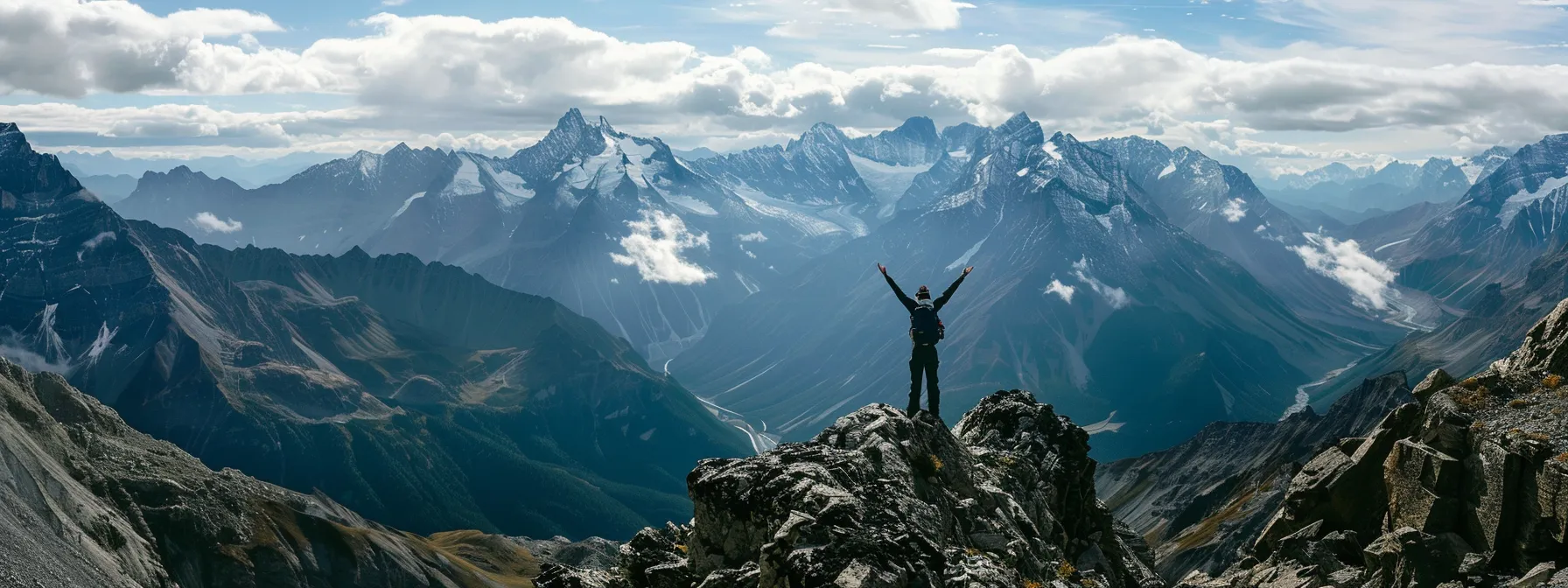 a person standing at the top of a mountain with arms raised, celebrating a personal achievement.