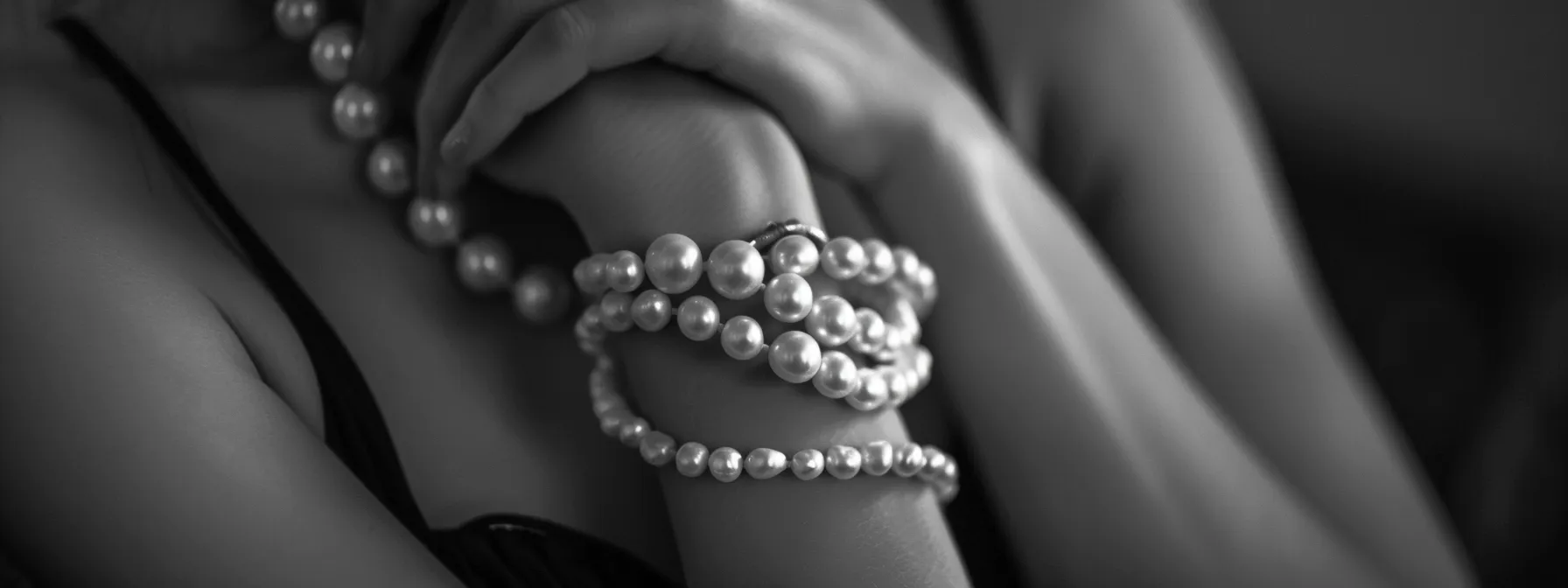 a pearl bracelet elegantly draped over a chic, monochrome outfit, adding a touch of sophistication and versatility.