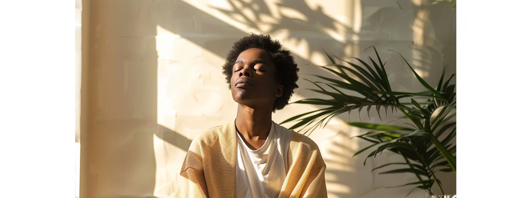 a person sitting in a serene setting, eyes closed, practicing heart-focused breathing with a peaceful expression on their face.