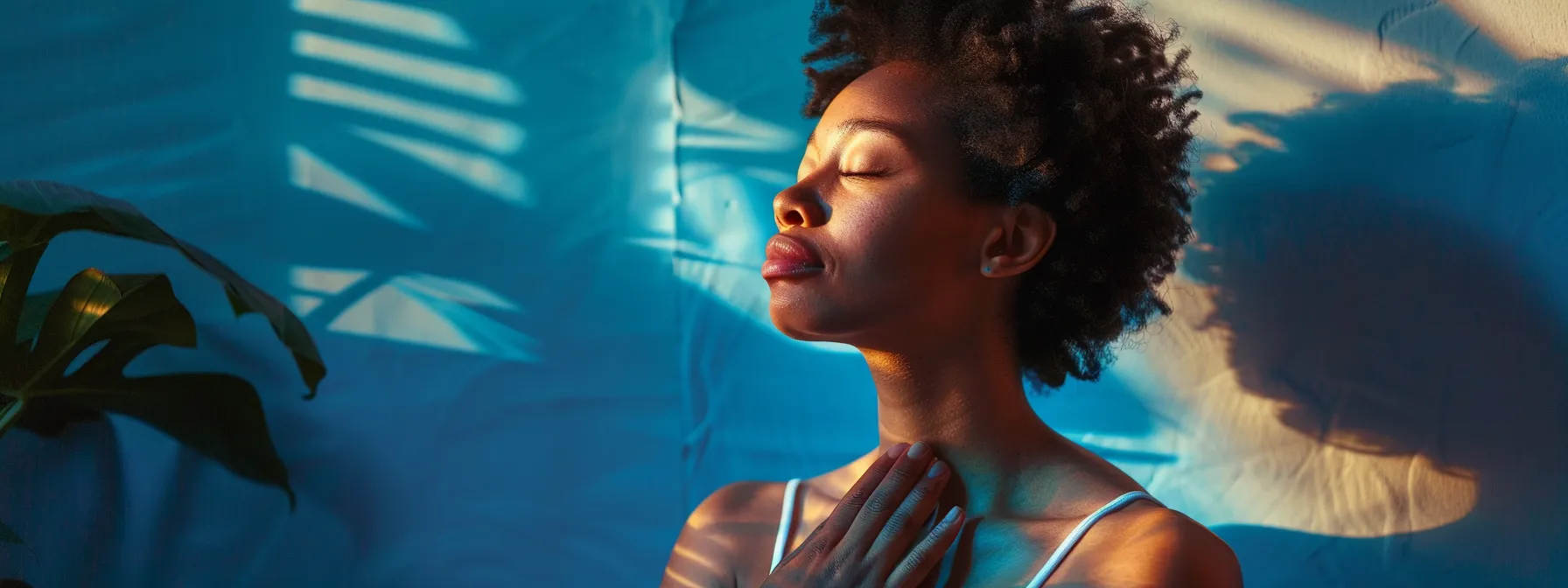 a person sitting peacefully with closed eyes, hands over heart, surrounded by a serene blue light, practicing the quick coherence technique.