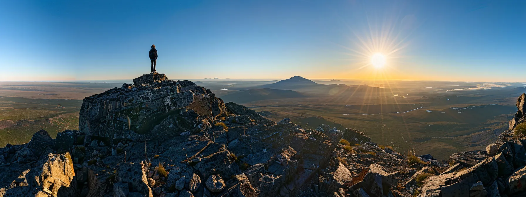 a person standing on top of a mountain, gazing out at a vast, endless horizon, representing the journey of continuous learning and growth towards success.