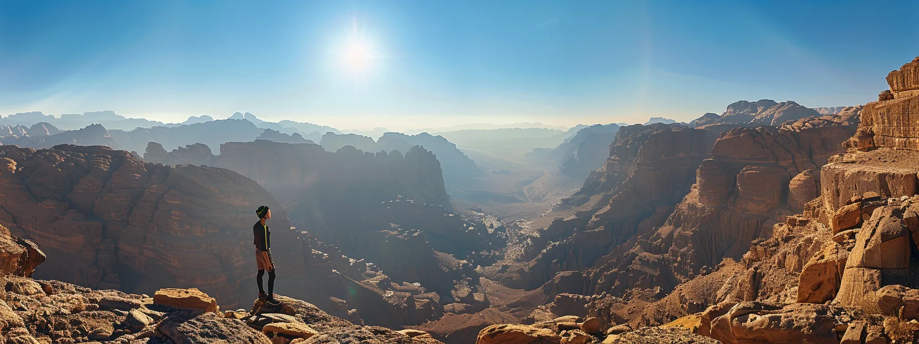 a person standing on top of a mountain, gazing at the expansive horizon, with a sense of accomplishment and determination in their eyes.