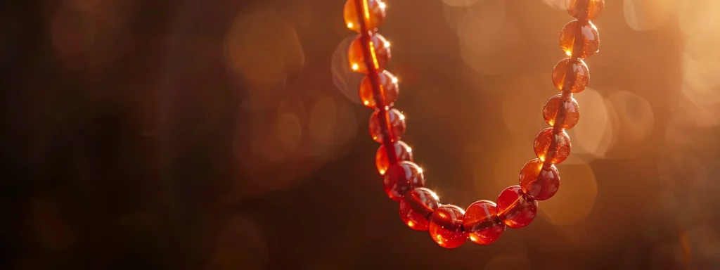 a stunning, fiery red carnelian necklace glistening in the sunlight against a dark background.