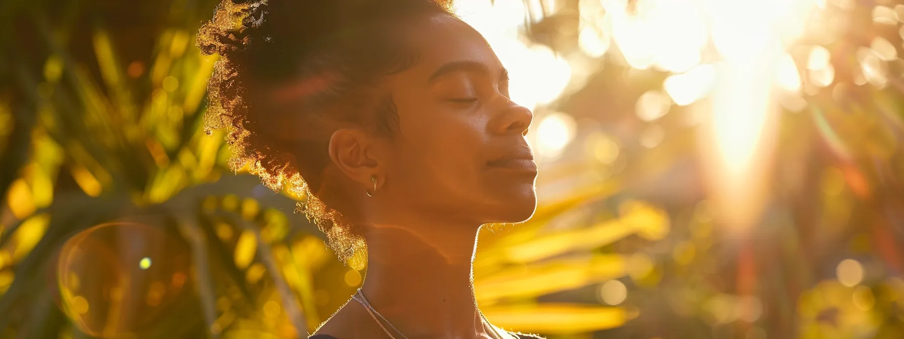 amidst a serene setting, a person chants the om hreem namah mantra with eyes closed, surrounded by vibrant, positive energy radiating from the words spoken.